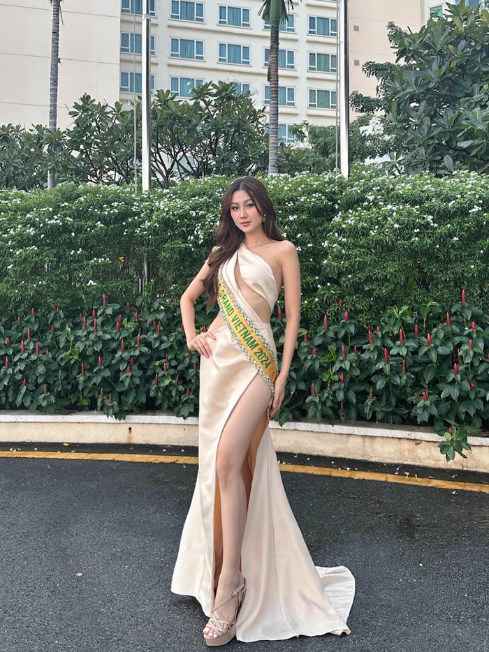 Ngày đầu nhập cuộc Miss Grand International 2024, Hoa hậu Quế Anh học ngay Thùy Tiên chiêu diện váy 'cut out' táo bạo. Thiết kế đầu tiên được cô đem 'ra quân' chính là mẫu váy mang màu beige nhã nhặn, form dáng bất đối xứng một bên vai và được tạo điểm nhấn bằng đường xẻ tà cao tận hông cùng loạt đường khoét phần ngực, eo.