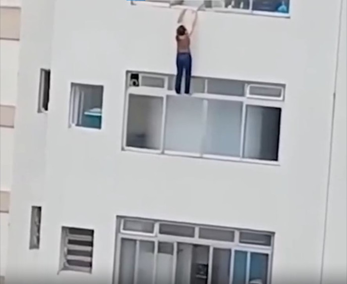 Hình ảnh người phụ nữ treo lủng lẳng ở tầng 16 chung cư.
