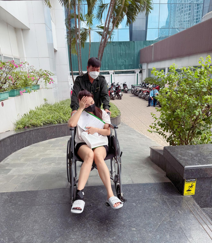 Bảo Thanh ngồi xe lăn khi đi thăm khám ở bệnh viện về vết thương ở chân. Ảnh: FBNV