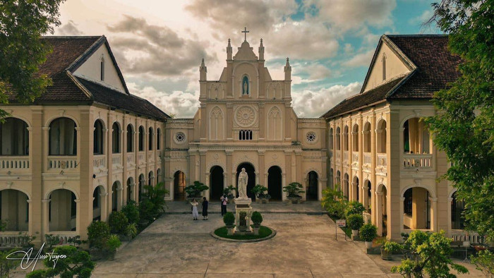 Chính diện thánh đường kết hợp cùng những tòa nhà hai tầng đối xứng nhau tạo nên sự hòa hợp trong một không gian rợp bóng cổ thụ, xanh tươi. Ảnh: Hữu Tuyển