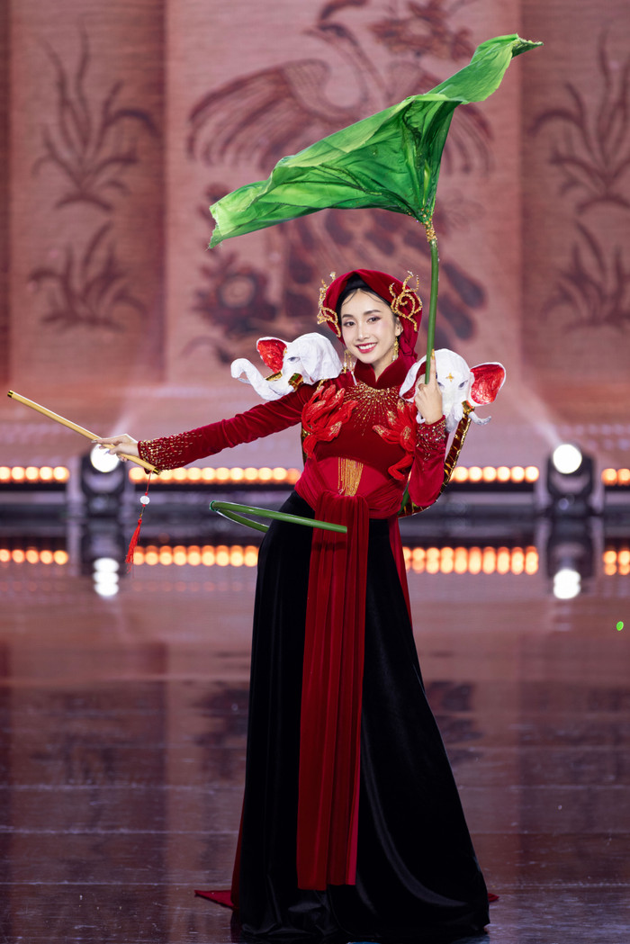 Người đẹp Trần Lê Huyền My, quê Lâm Đồng trình diễn uyển chuyển trong thiết kế 'Hương Đông Hồ'.  Bộ trang phục được lấy ý tưởng chính từ làng nghề làm tranh đông hồ truyền thống ở xứ Kinh Bắc. Đặc biệt, hình 'Chăn Trâu Thổi Sáo'  và 'Bà Triệu' trên thiết kế là 2 bức tranh quen thuộc của dòng tranh đông hồ Việt Nam, mang trên mình những giá trị văn hoá đặc sắc, khi được kết hợp gợi cảm giác, thân quen, êm ả, bình dị của làng quê Việt Nam và mang tinh thần yêu nước mạnh mẽ của dân tộc ta. 