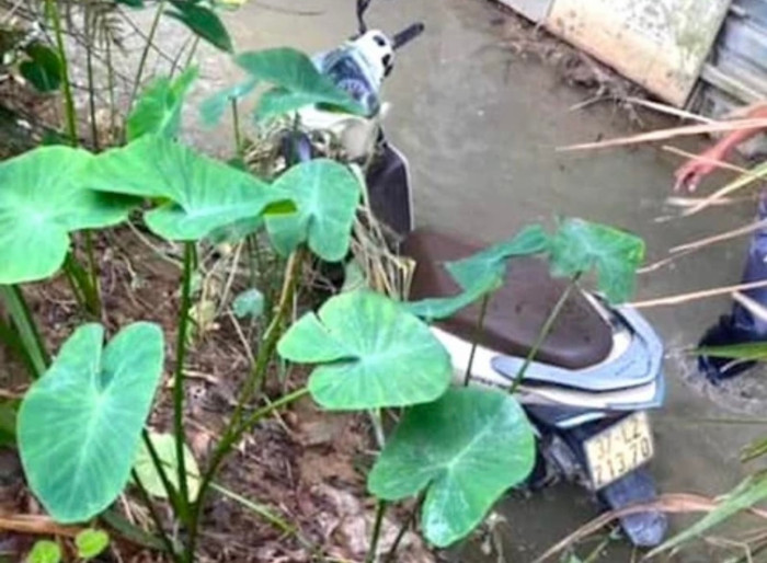 Thi thể nạn nhân và chiếc xe máy được phát hiện dưới mương nước cầu vượt Yên Lý.