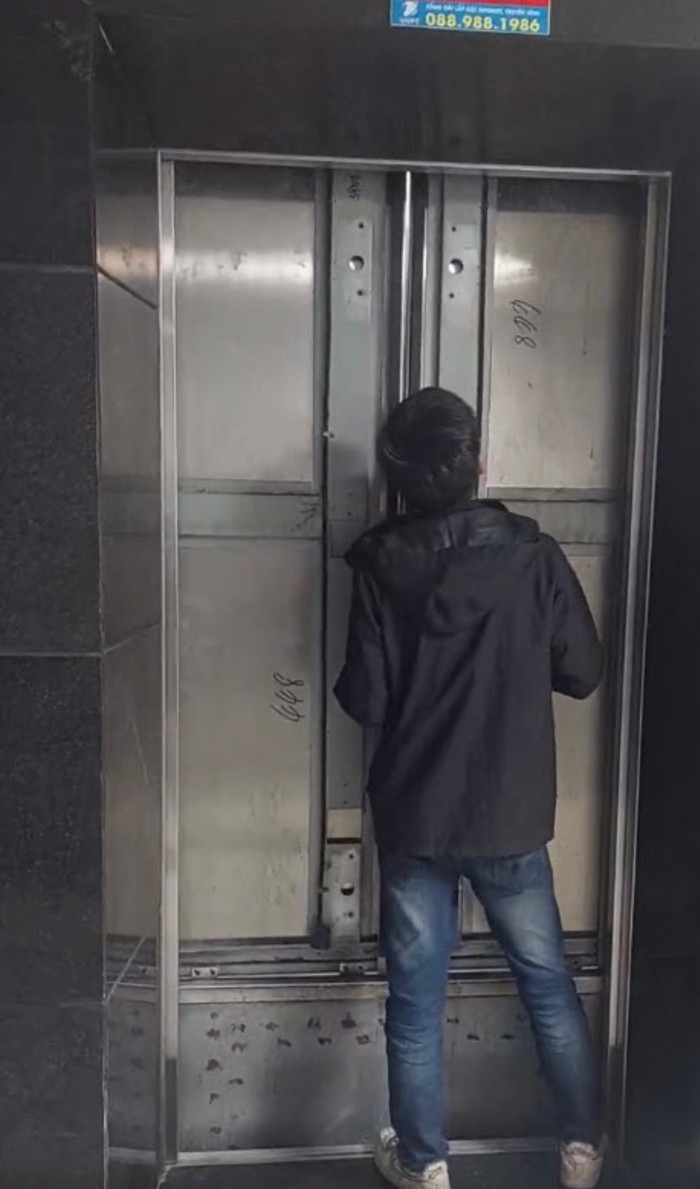 Bảo vệ tòa nhà cạy cửa để người dân đi ra.