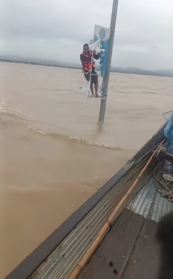 Cụ ông bám vào cột điện giữa dòng nước lũ được lực lượng chức năng tìm thấy. 