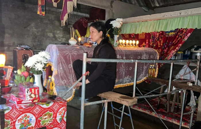 Đã ba ngày liền, chị Kiều ngồi cạnh quan tài của cha với vẻ mặt đau buồn. Ảnh: B.T