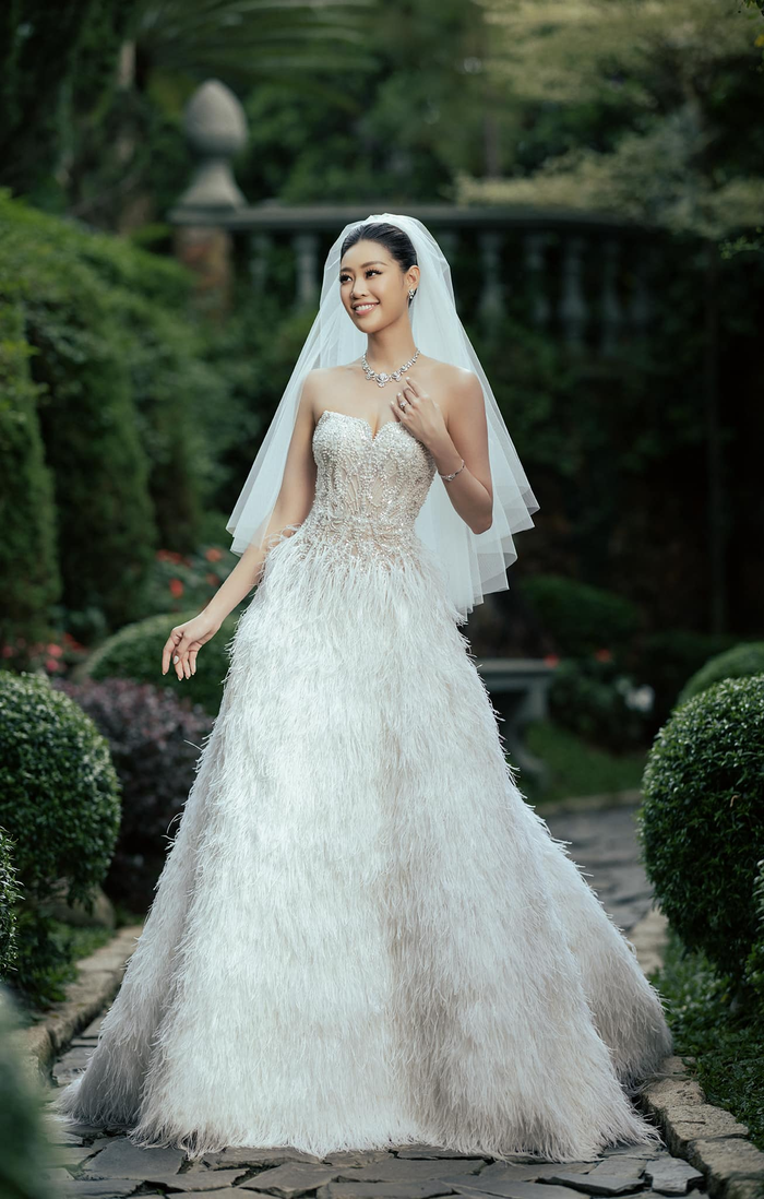 Người đẹp diện mẫu váy cưới đến từ nhà thiết kế Lê Thanh Hòa. Trang phục có phom dáng chữ A, quây cúp ngực kết hợp chất liệu tuyn kết hợp lông vũ. Thân áo được đính kết đá tinh xảo.
