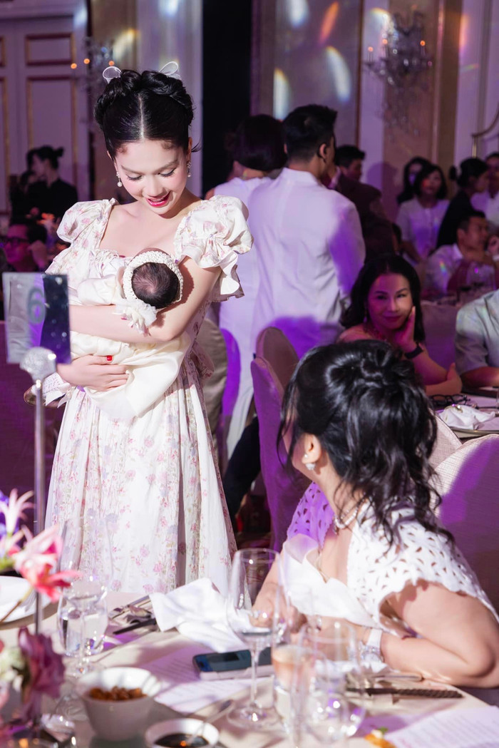 Showbiz 29/10: Ngọc Trinh vui vẻ bế con gái Chi Bảo trong tiệc đầy tháng. Ảnh: FBNV