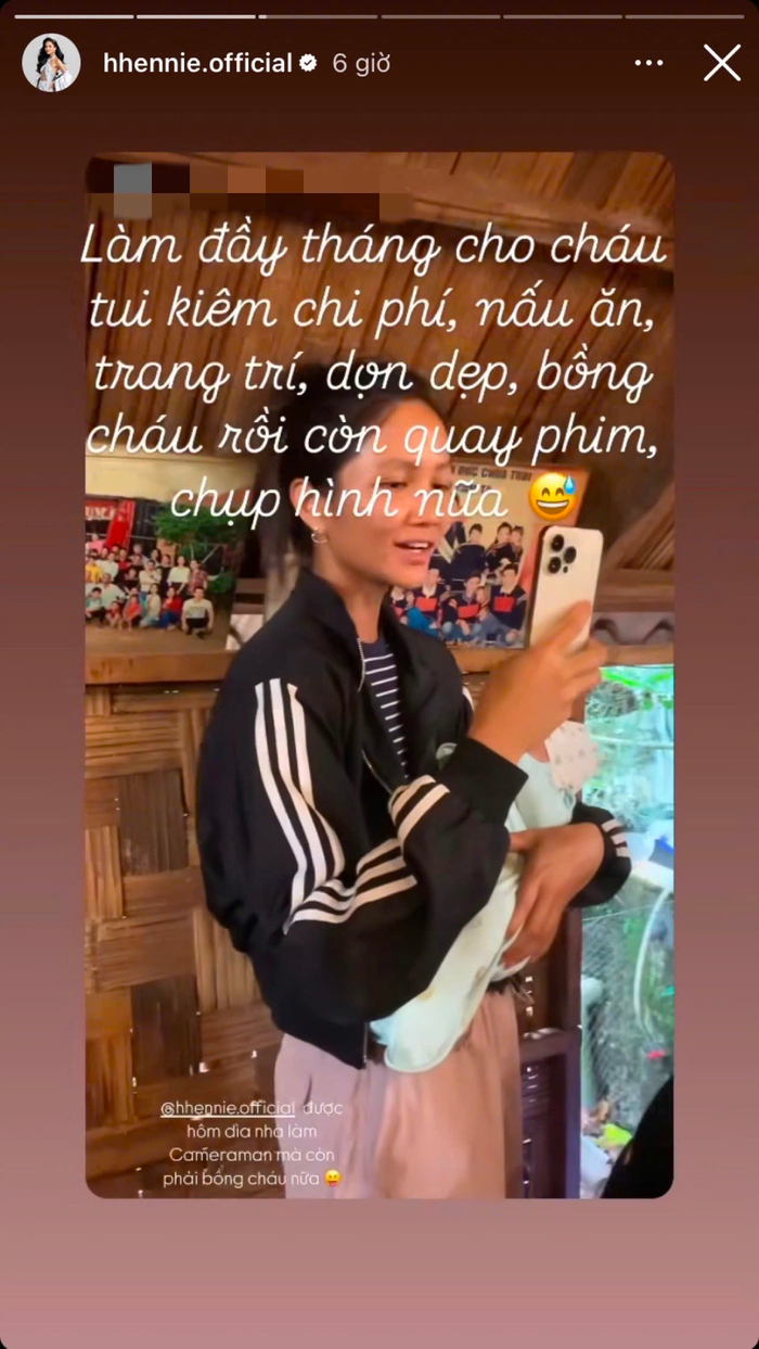 H'Hen Niê vui vẻ bế cháu, dùng điện thoại ghi lại mọi khoảnh khắc trong bữa tiệc. Ảnh: Chụp màn hình