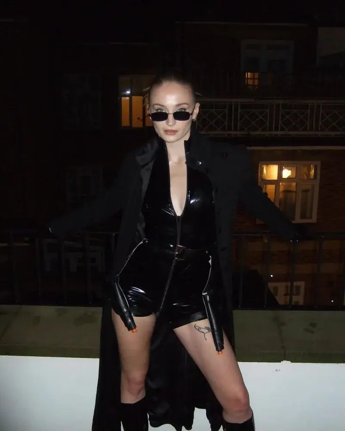 -Sophie Turner hóa thân thành Trinity trong Ma Trận. Nữ diễn viên gây ấn tượng với bộ trang phục mang phong cách lạnh lùng và mạnh mẽ của Trinity, nhân vật biểu tượng trong thế giới phim viễn tưởng của The Matrix.