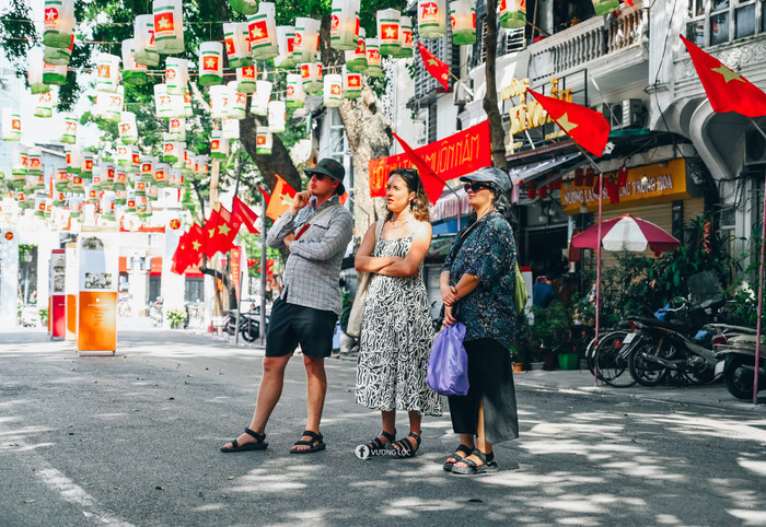 Du khách nước ngoài thích thú chiêm ngưỡng không gian tràn đầy sắc màu rực rỡ và khí thế hào hùng tại phố bích hoạ Phùng Hưng.