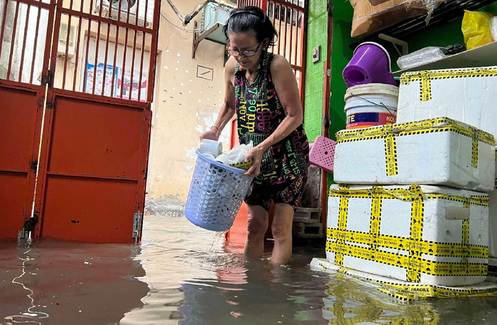 Sân nhà bà Thiện ở hẻm 432 đường Xô Viết Nghệ Tĩnh (Q.Bình Thạnh), nước ngập cao. 'Mỗi lần mưa to là hẻm ngày ngập nên không dám đi đâu, phải ở nhà để dọn đồ', bà nói -  Ảnh: Thanh niên