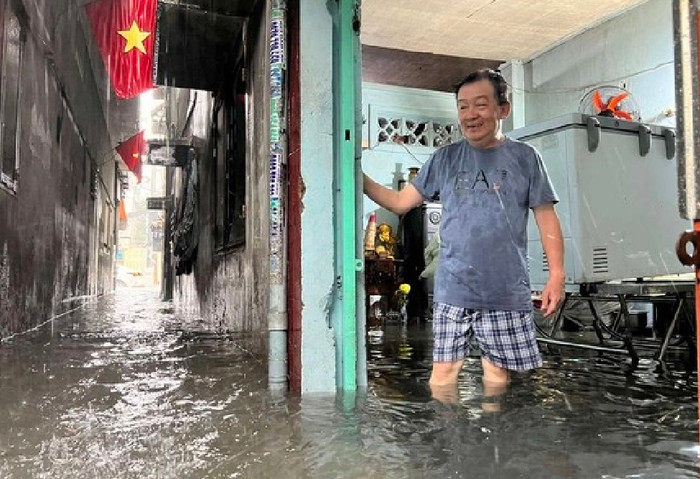 Nhà ông Hòa ở mặt tiền đường D5 (Q.Bình Thạnh) nước ngập gần tới đầu gối. Ông Hoà cho biết trận mưa này gây ngập sâu nhất từ đầu mùa mưa đến giờ. Hôm qua nước cũng ngập sâu gia đình không kịp trở tay -  Ảnh: Thanh niên
