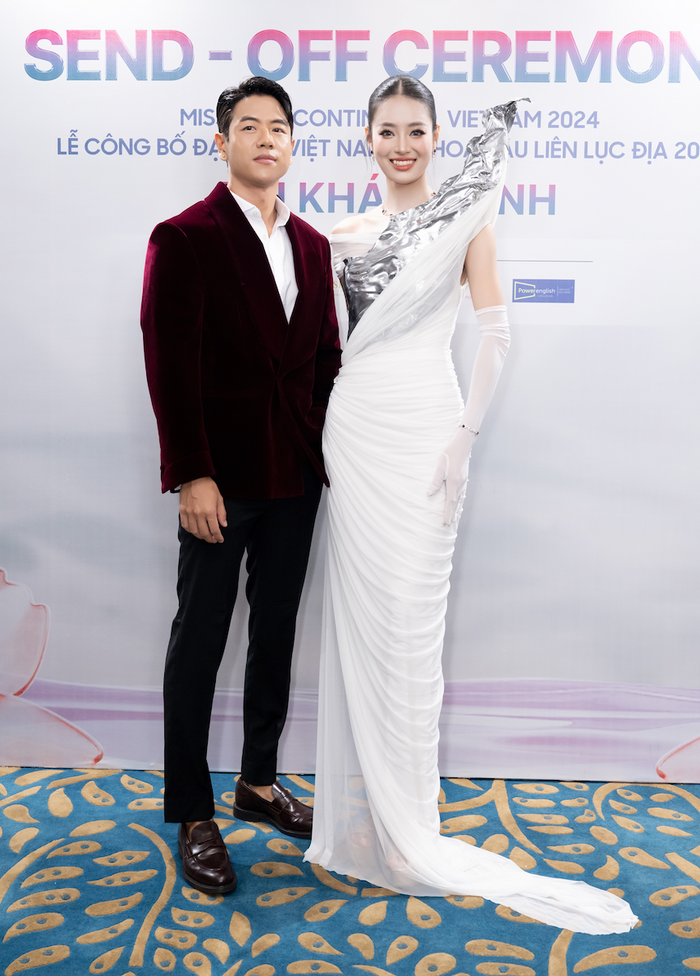 Michael Trương diện bộ vest đỏ cực kỳ phong độ đến chúc mừng sự kiện của đàn em. Anh chàng còn tinh tế chỉnh váy cho Khánh Linh trong lúc tạo dáng. 