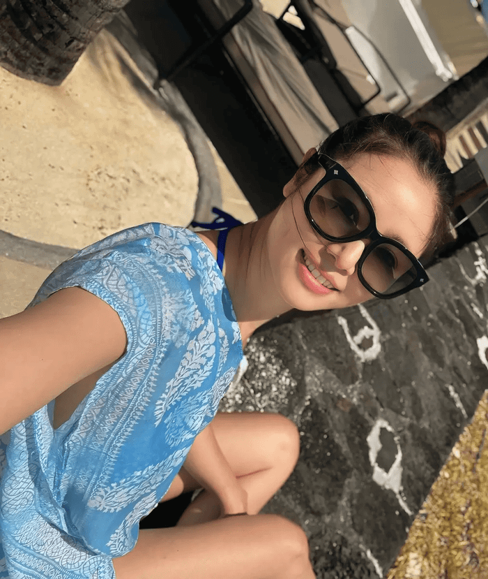 Lâm Tâm Như đeo kính râm, khéo khoe làn da căng bóng khoẻ mạnh dưới ánh mặt trời. Ảnh: Sưu tầm