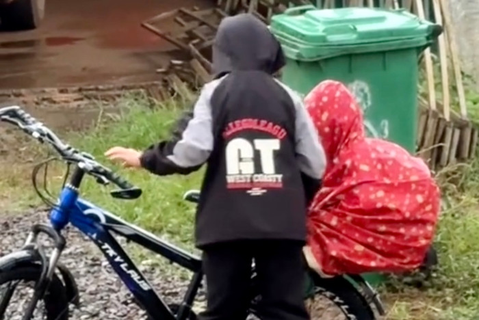 Cảm động hình ảnh anh nhường áo mưa cho em trai dưới cơn mưa xối xả.