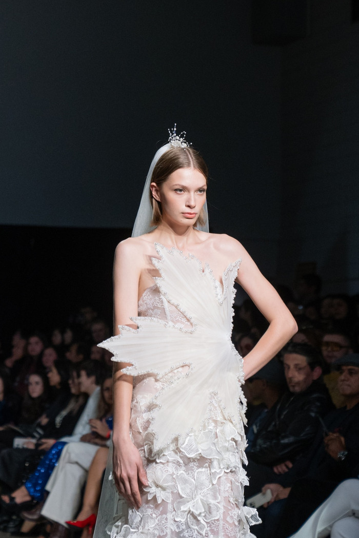 Bộ váy cưới cách điệu từ nhiều hoạ tiết hoa, lá được đính lên trên là các mẫu ngọc trai.