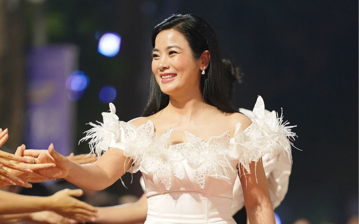 Diễn viên Đàm Hằng diện váy dạ hội trễ nải, đính lông vũ đẹp mắt, thân thiện bắt tay, giao lưu với khán giả.
