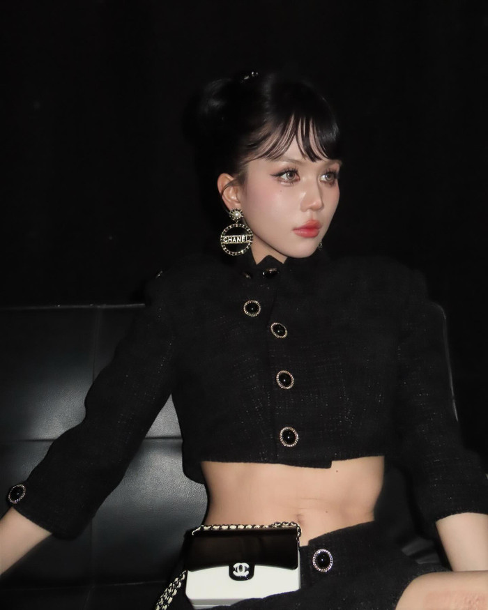 Nếu không muốn quá gợi cảm, bạn cũng có thể diện set đồ áo croptop nút viền vàng kết hợp quần ngắn cùng tông màu. Ngọc Trinh đeo thêm túi nhỏ mini cùng phụ kiện hoa tay bản lớn khiến tổng thể trở nên quý phái dù không khoe hình thể. 