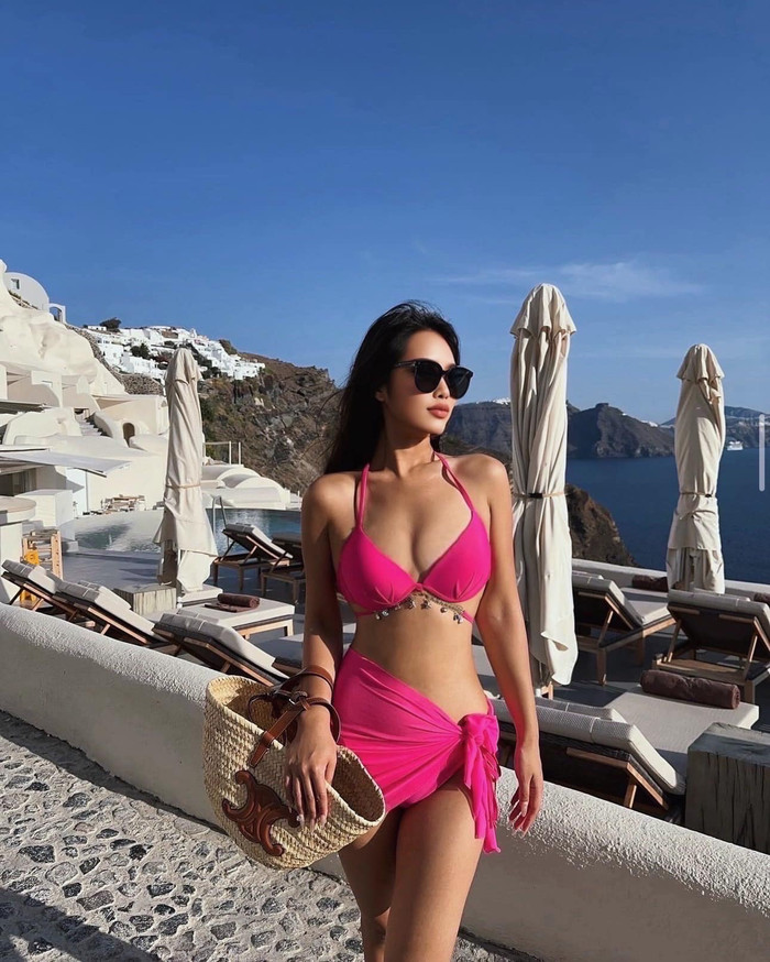 Trong chuyến vui du lịch biển, BiVi Vũ lựa chọn thiết kế bikini cắt xẻ, mang tông màu hồng neon tôn lên làn da nâu bóng quyến rũ. Bạn gái Hồng Thanh phối cùng phụ kiện kính mát đen và túi xách chất liệu cói từ 'nhà mốt' đình đám của Pháp. Item này được bán với mức giá dao động từ 10 - 20 triệu đồng.
