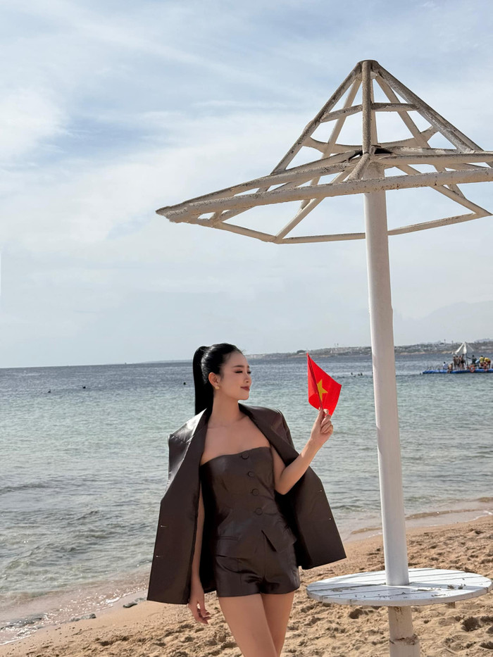 Để nâng cao giao diện, Bùi Khánh Linh cầm trên tay là cờ đỏ sao vàng. Nàng hậu nở nụ tười tươi tắn trước ống kính máy quan của bạn bè quốc tế. Sự thể hiện của cô nàng cho thấy sự đầu tư nghiêm túc, tinh thần chiến đấu hết mình cho dải sash Vietnam. Được biết, đây cũng là lần đầu tiên Bùi Khánh Linh mang chuông đi đánh xứ người. 