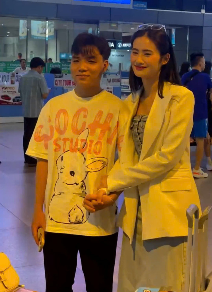 Bạn trai Anh Kiệt có mặt tại sân bay từ sớm để đón nàng hậu. Xuất hiện trong ống kính, Anh Kiệt ăn vận đơn giản với áo phông họa tiết cùng ống suông đen. Cặp đôi tự nhiên tương tác với người hâm mộ có mặt tại hiện trường.