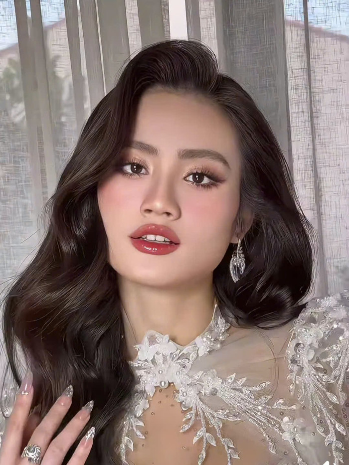 Khác hình ảnh 'nàng thơ' tại sự kiện thời trang tối 22/11, Hoa hậu Ý Nhi đã có sự cải tiến trong việc lựa chọn tạo hình. Nàng hậu ưu ái thể hiện hình ảnh nàng dâu ngọt ngào nhưng không kém phần sắc sảo với layout trang điểm và làm tóc cuốn hút.  