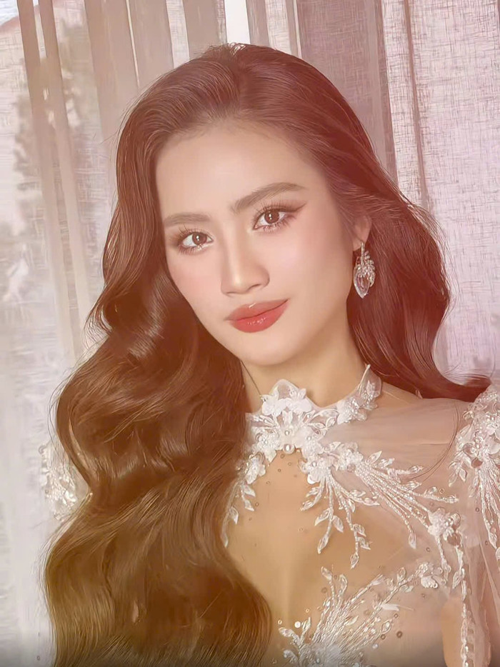 Kiểu tóc uốn sóng lơi bản lớn, rẽ ngôi lệch góp phần khoe ngũ quan của cô. Không những vậy, lối trang điểm đậm, kiểu kẻ mắt vuốt cong hòa cùng đôi môi cam đào căng mọng mang lại vẻ ngoài trẻ trung, sắc sảo cho Hoa hậu Ý Nhi. Để nâng cấp sự thời thượng, cô còn sử dụng thêm phụ kiện khuyên tai trái tim ánh bạc bản lớn.  