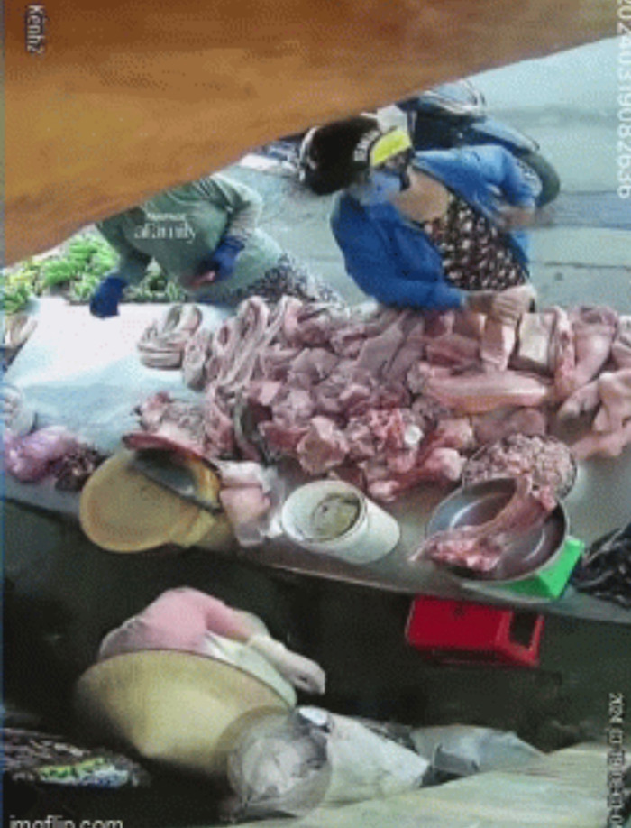 Người phụ nữ nhanh chóng thó miếng thịt kẹp vào nách.