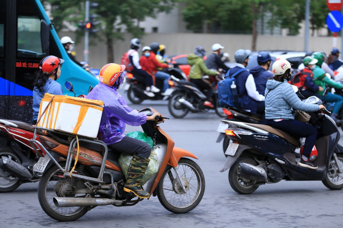 Có người phải mặc áo mưa, đi ủng để chống lại cái rét