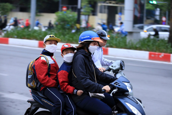 Phụ huynh mặc ấm cho con đưa đến trường