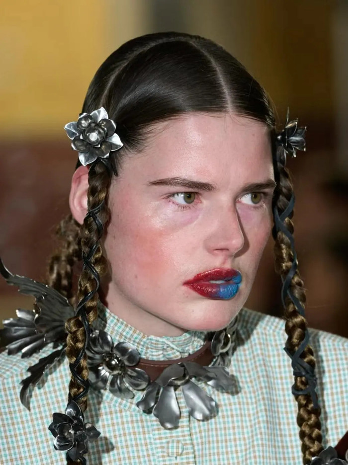 Phụ kiện tóc không còn chỉ là chi tiết nhỏ trong phong cách, mùa này chúng đã được nâng tầm để trở thành tâm điểm. Các sàn diễn, đặc biệt tại Tuần lễ thời trang London đã chứng kiến sự bùng nổ của những món đồ trang trí tóc kích thước lớn. Những bông hoa khổng lồ, băng đô bản to với thiết kế phức tạp đã biến kiểu tóc đơn giản thành tác phẩm nghệ thuật đậm chất sân khấu.
