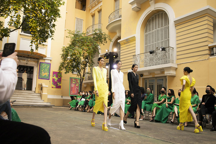 Show diễn Bình Minh 2022 ở Bảo tàng Mỹ thuật Thành phố. Sàn runway được gói gọn trong khuôn viên sân nội khu của Bảo tàng, lấp ló sau tán cây xanh mướt. Sắc vàng cổ kính trên mảng tường, cùng độ vàng ngọt của những quả thị tạo nên một sàn runway khác lạ so với thông lệ của hai nhà thiết kế. 