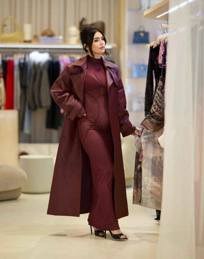 Megan không ngại khoe bụng bầu lớn trong chiếc váy bó sát màu đỏ tía trong bộ sưu tập Camila Coelho của Revolve, vì chất vải của váy quá mỏng để lộ cả bộ áo ngực và đồ lót của cô. Người đẹp kết hợp vẻ ngoài trong suốt với chiếc áo khoác da Ducie giá 1,300 USD và giày cao gót Tony Bianco màu đen. 