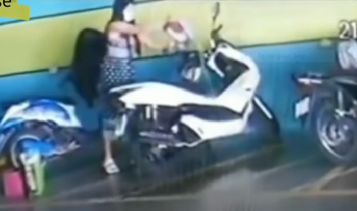 Hình ảnh cô gái tưới xăng vào xe rồi châm lửa đốt.