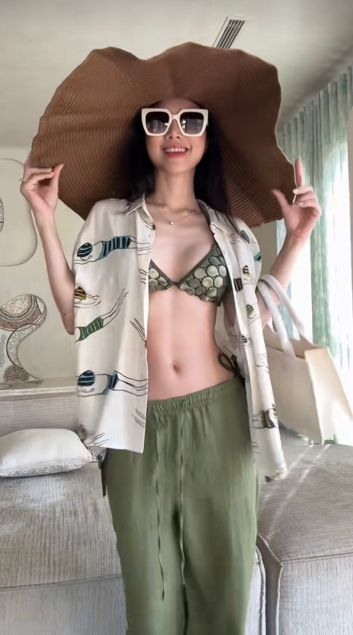 Để tránh bị 'hớ hênh' quá mức, Đinh Ngọc Diệp khoác thêm áo có cùng tông màu với áo bikini kết hợp thêm nón cối to vành làm tăng đội sành điệu. 
