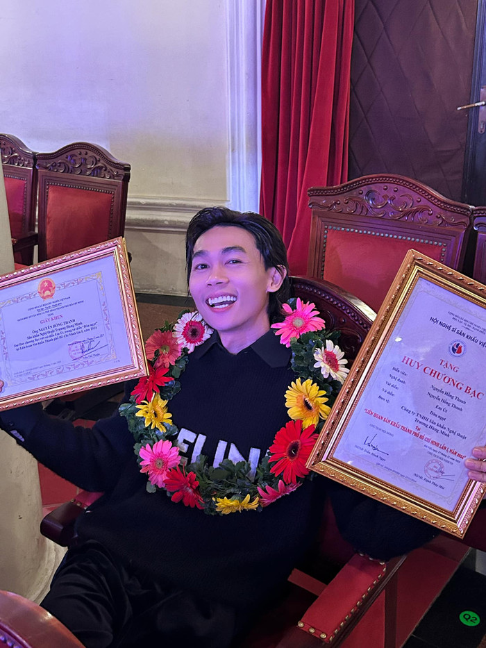 Hồng Thanh hạnh phúc chụp ảnh bên cạnh hai bằng khen. Ảnh: FBNV