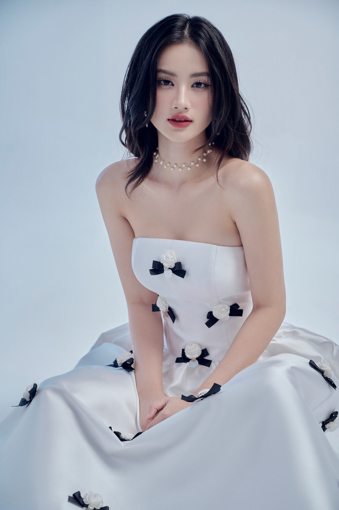 Không chỉ diện những thiết kế váy cúp ngực, 'trễ nải' mang tông màu đơn sắc thanh lịch, Hoa hậu Ý Nhi từng trưng dụng cả thiết kế đính dày đặc hoạ tiết nơ và hoa. Người đẹp Bình Định còn phối cùng phụ kiện vòng cổ ngọc trai lấp lánh. Hướng đi này giúp cô khoe khéo nhan sắc ngọt ngào, trong trẻo.