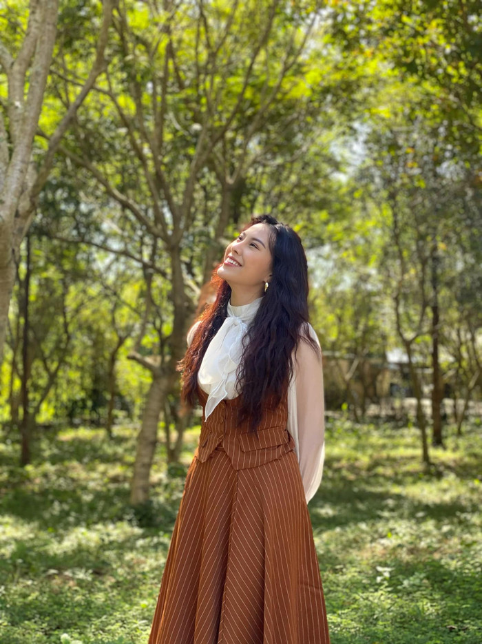 Chu Lê Vi Anh ưa chuộng phong cách thời trang thanh lịch, khoe khéo nhan sắc trong trẻo. Trong hình ảnh trên, người đẹp khoác lên người bản phối gồm chân váy dài, form dáng xoè cùng mẫu áo sơ mi cách điệu phần cổ. Chu Lê Vi Anh 'trưng dụng' thêm chiếc áo ghi lê ôm sát, tôn lên vòng eo nhỏ xíu. Tổng thể outfit của cô mang đậm tinh thần thanh lịch và sự khéo léo trong cách phối hai gam màu nâu đất - trắng.