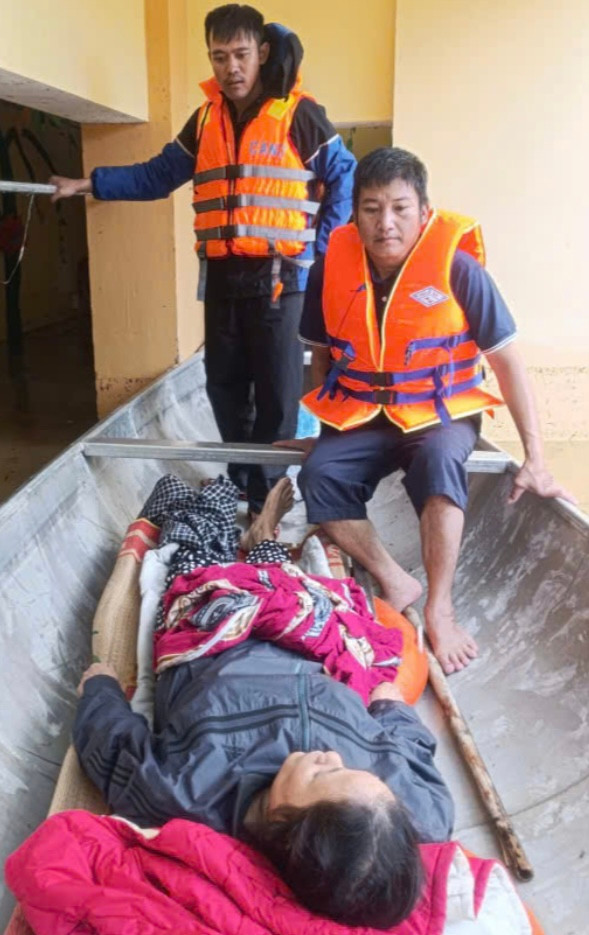 Lực lượng chức năng xã An Thủy dùng ghe nhôm đưa bà Lâm vượt lũ đến bệnh viện cấp cứu - Ảnh: Người Lao Động.