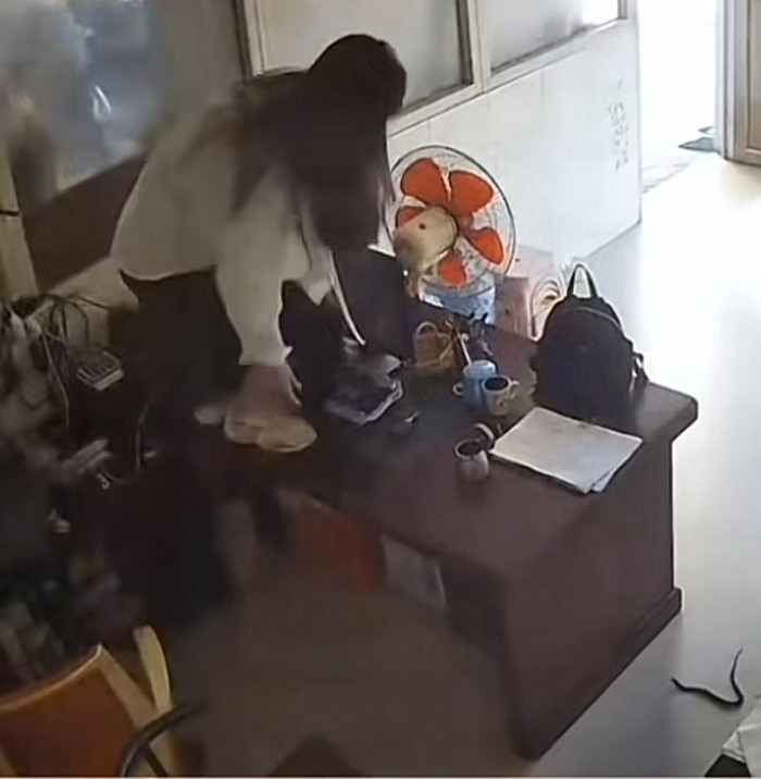 Hoảng hốt, cô gái lập tức nhảy lên bàn tránh sự tấn công từ con rắn.