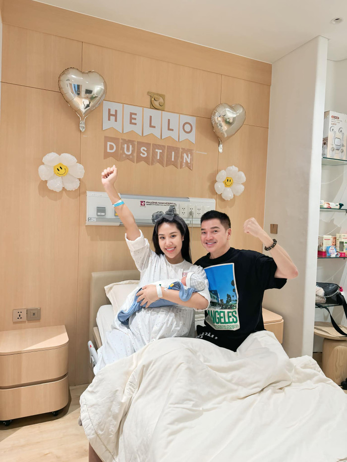 Nghệ sĩ Quang Minh và bạn gái vui vẻ chụp ảnh cùng quý tử đầu lòng. Ảnh: FBNV