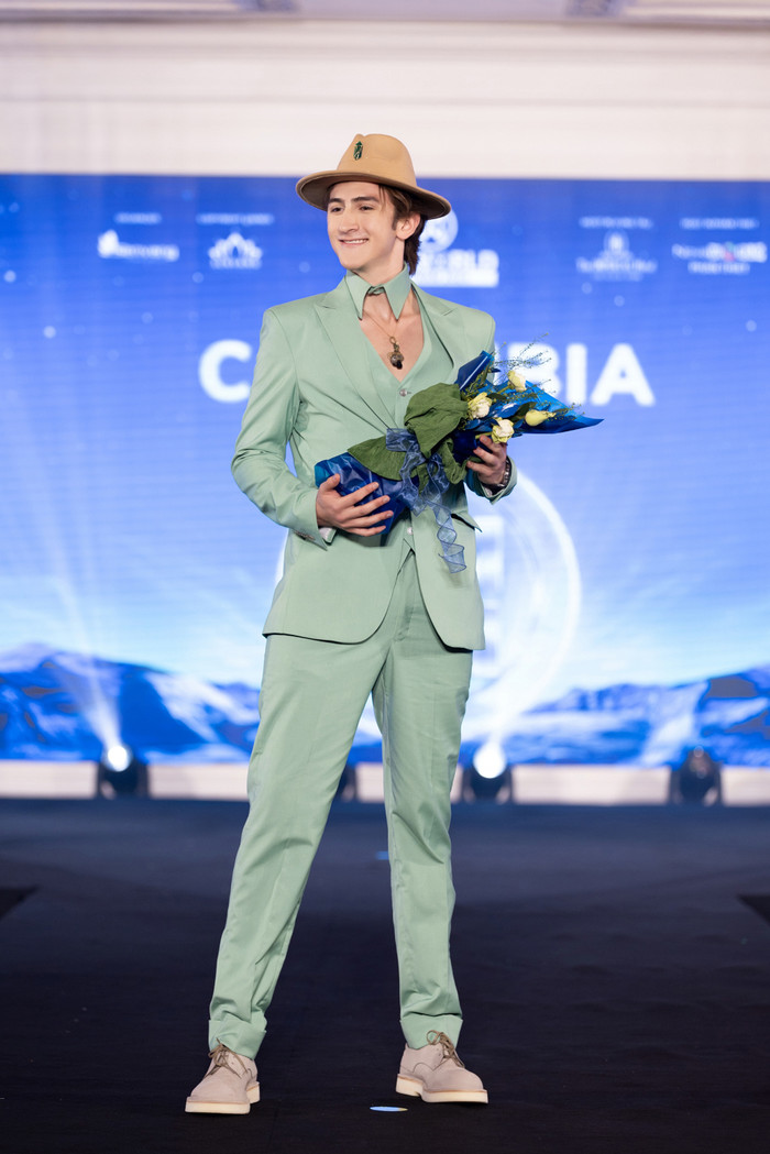 Đại diện Colombia - Juan Esteban Rodriguez chỉ vừa 18 tuổi nhưng anh chàng cao 1m95 cùng gu ăn mặc khác biệt. Juan chọn bộ vest khoét ngực màu xanh mint kết hợp nón cao bồi nâu giúp tôn vẻ điển trai chuẩn Latinh. 