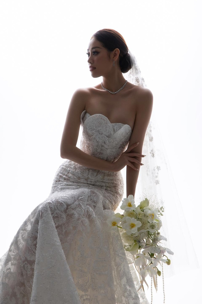 Chiều 9/11, Hoa hậu Khánh Vân tung bộ ảnh khoe chiếc váy cưới thứ ba chuẩn bị trước thềm hôn lễ. Đúng với tinh thần thanh lịch từ đầu, thiết kế vẫn là dạng đầm quây đuôi cá khoét ngực giúp nàng hậu khoe được bờ vai thanh mảnh. 