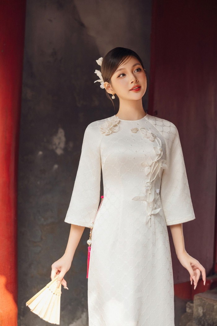 Tà áo dài luôn là biểu tượng của sự duyên dáng và thanh lịch, nay được tô điểm bằng những chi tiết hoa đính nổi càng làm tăng thêm vẻ cuốn hút đặc biệt. Gam màu nhẹ nhàng mang đến cảm giác uyển chuyển, như những cánh hoa xuân đầu mùa, vừa mong manh, vừa kiêu hãnh.
