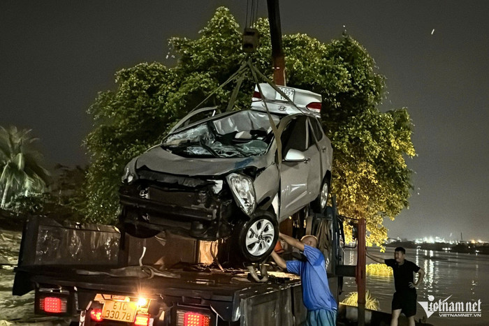 Lực lượng chức năng trục vớt chiếc ô tô gặp nạn lên. Ảnh: VietNamNet