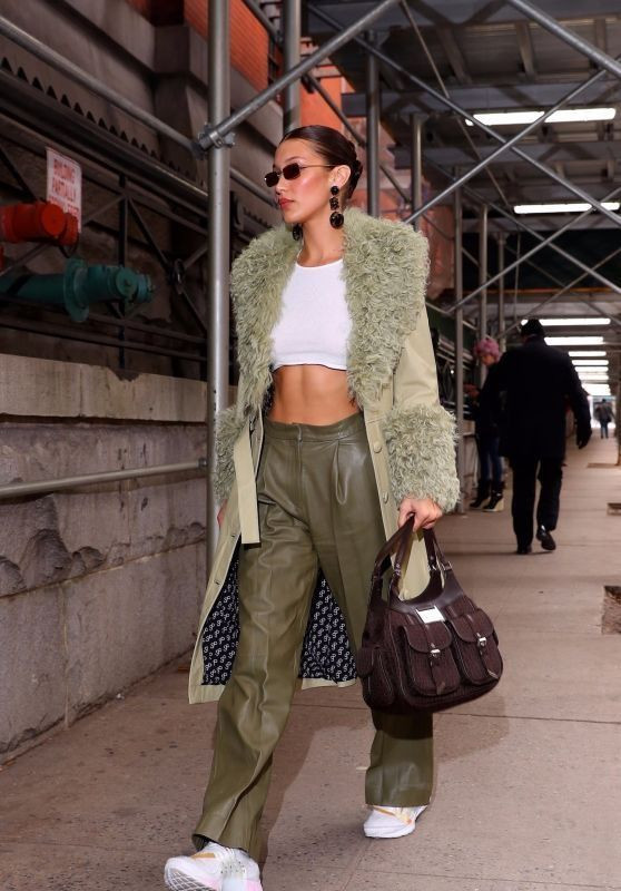 Áo khoác lông cừu là biểu tượng của sự xa hoa trong mùa đông. Bella Hadid kết hợp chiếc áo này với váy lụa bandeau và áo len cardigan mỏng. Cô chọn bốt da nâu cao đến gối để tăng thêm nét cổ điển, đồng thời phối trang sức kim loại để tạo sự tươi mới. 