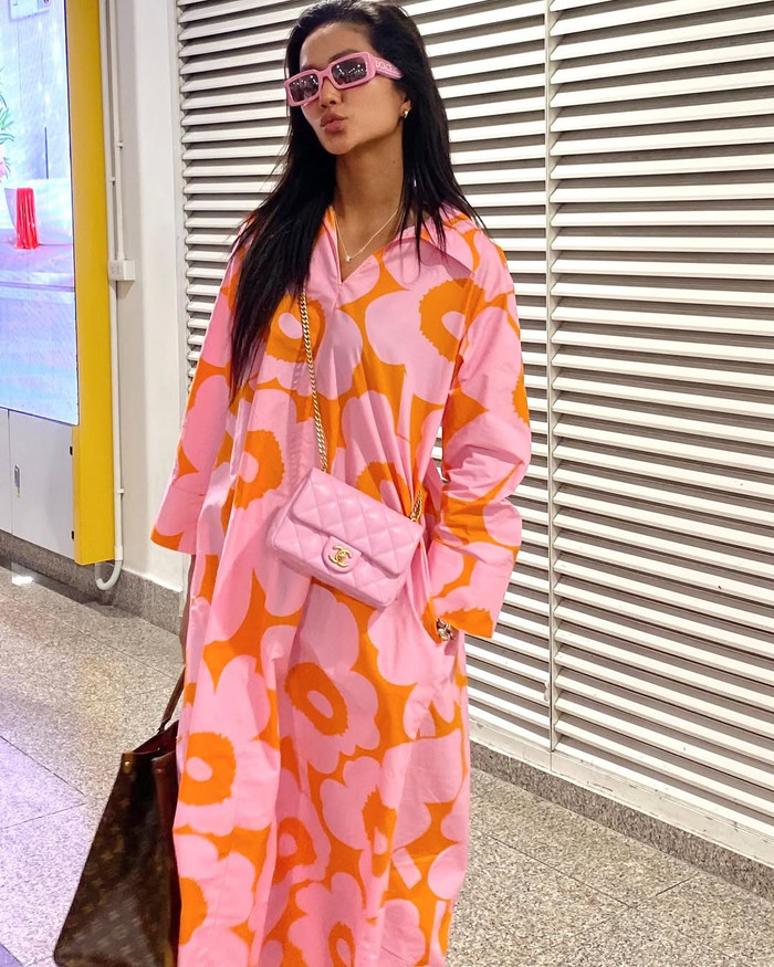 Trang phục sân bay của H'Hen Niê được đánh giá đơn giản nhưng không kém phần nổi bật nhờ những item mang tông màu nóng. Cựu Hoa hậu Hoàn vũ Việt Nam cũng không quên tô điểm cho outfit bằng mẫu túi xách đồng màu hồng đến từ thương hiệu có Jennie (BLACKPINK) làm đại sứ toàn cầu. Thiết kế này có mức giá khoảng 170 triệu đồng. Bên cạnh đó, H'Hen Niê còn xách thêm mẫu túi tote, hoạ tiết monogram mang giá trị khoảng 83 triệu đồng. (Ảnh: FBNV)