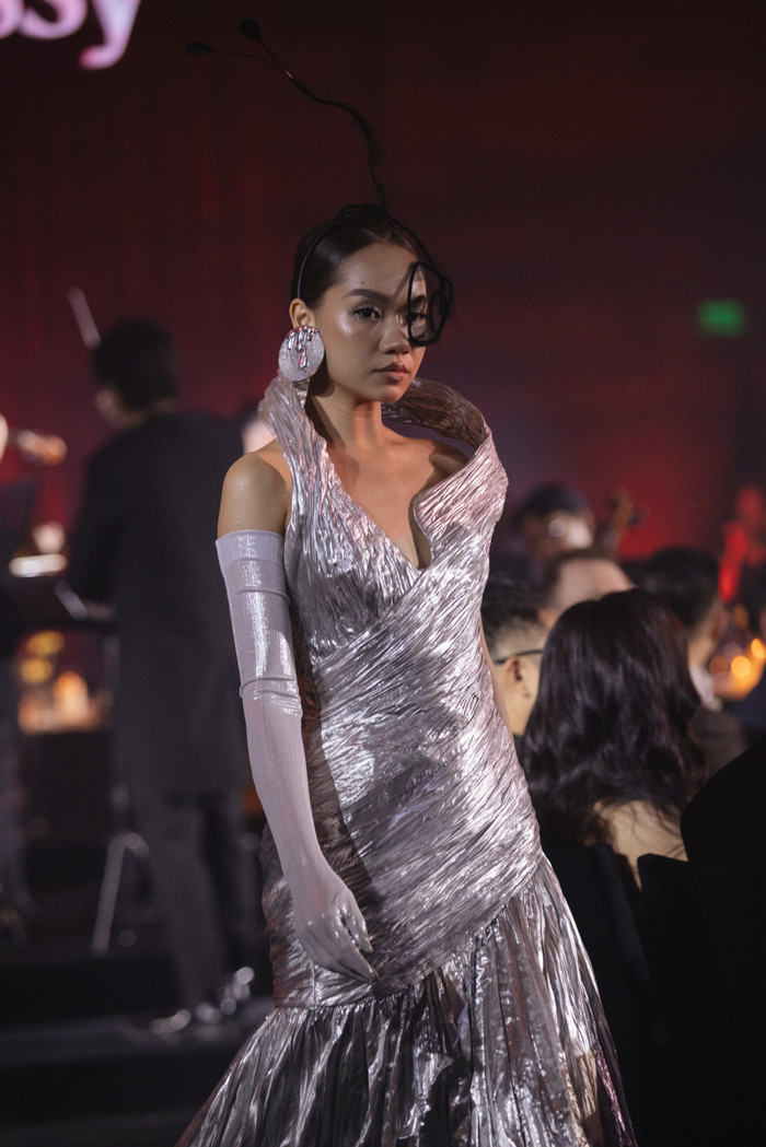 Sự đối lập giữa vẻ đẹp mong manh và sức mạnh nội tại mạnh mẽ được thể hiện qua cách phối màu hài hòa giữa các sắc độ nhẹ nhàng như pastel, xám, be với tông màu nóng như đỏ và cam, thể hiện sự biến chuyển từ tĩnh lặng đến bùng nổ. 