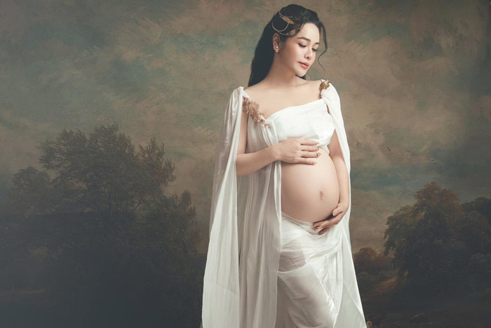 Nhật Kim Anh diện váy trắng, khéo khoe bụng bầu vượt mặt. Ảnh: FBNV