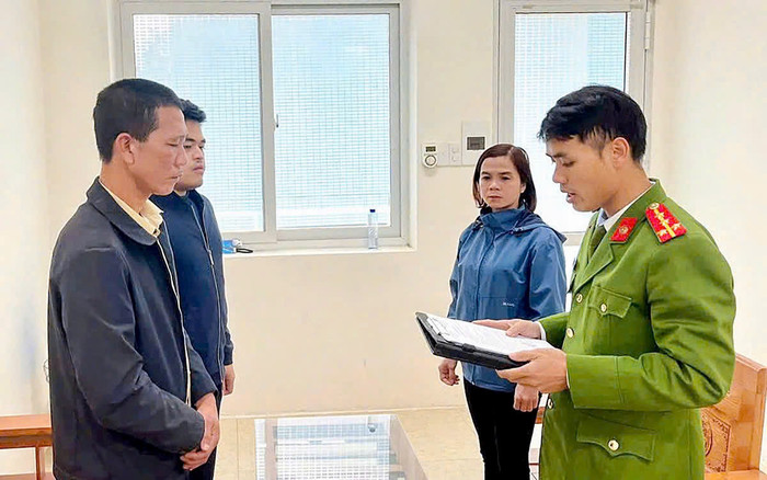 Lê Văn Tuấn tại cơ quan công an (áo đen). 